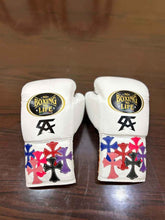 Custom No Boxing No Life professional lace-up boxing gloves in white leather featuring black Canelo Alvarez CA logos and multiple layered multi-color leather cross patches stitched onto the cuffs.