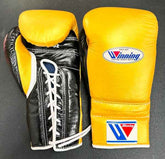 Custom Winning professional lace-up training boxing gloves in a yellow and black leather colorway featuring white laces, white contrast edge trim, and the iconic brand logo crest on the cuffs.