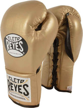 Official Cleto Reyes professional training boxing glove in gold metallic leather featuring a high-sheen champagne finish, a black printed brand insignia, and a stitched wrist cuff patch.