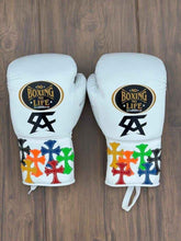 No Boxing No Life professional lace-up boxing gloves in white leather featuring a black Canelo Alvarez CA logo and multicolored custom leather cross patches on the cuffs.