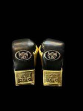 Authentic black and metallic gold No Boxing No Life professional boxing gloves handcrafted in Mexico with official branding.