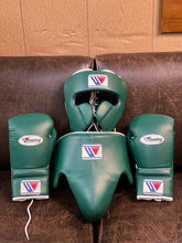 Winning professional custom 3-piece boxing sparring gear set featuring a matching lace-up glove pair, full-face headguard, and groinguard in uniform British racing green leather with white trim accents.