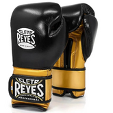 Official Cleto Reyes professional hook-and-loop training boxing gloves featuring a sleek black leather punching face paired with high-sheen gold metallic leather palms, thumbs, and wrist cuffs.