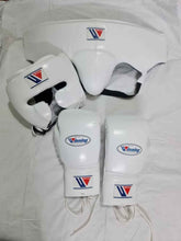 Official Winning professional 3-piece boxing sparring gear set in a matching classic white premium leather colorway, featuring lace-up training gloves, a face guard headgear, and a groin protector grouped together over a white sheet backdrop.