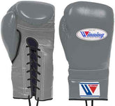 Custom Winning professional lace-up boxing gloves in slate gray leather featuring official brand patches, black trim accents, and contrasting black laces.