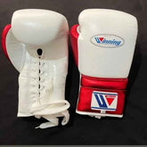 Custom Winning professional lace-up boxing gloves in white leather featuring a metallic red thumb, metallic red cuff area, official brand patches, and white laces.