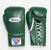 A pair of green leather boxing gloves with white laces and white trim, featuring the Winning brand logo on the front and wrist strap, displayed on a white background.