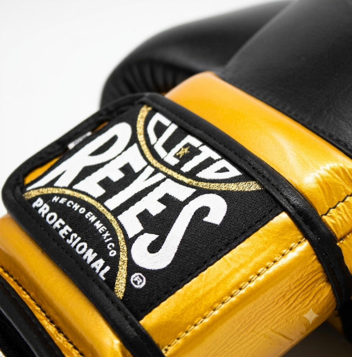 Close-up of Cleto Reyes black and gold leather boxing glove showing brand patch and texture