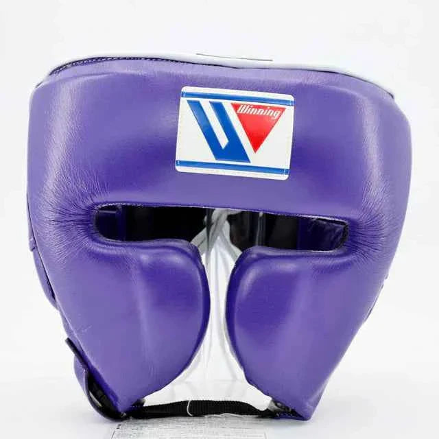 Official Winning FG-2900 professional boxing cheek-protection headgear in classic purple premium leather featuring the iconic brand logo crest patch centered on the forehead.