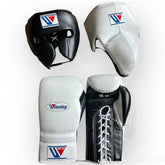 Custom Winning professional 3-piece boxing sparring gear set featuring black and white leather dual-tone lace-up gloves, a black face guard headgear, and a white groin protector over a white background.