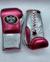 No Boxing No Life professional lace-up boxing gloves in metallic pink leather with a metallic silver thumb, palm, and cuff area featuring the official brand patch and contrasting white laces.