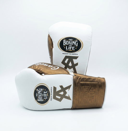 White leather boxing gloves with metallic bronze cuffs
