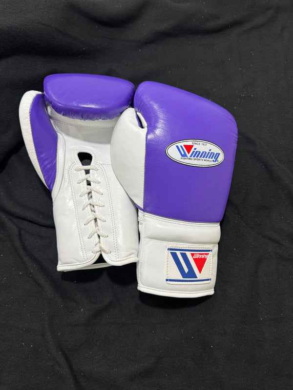 Custom Winning professional lace-up training boxing gloves in a vibrant purple and white leather colorway featuring white laces and the iconic brand logo crest on the cuffs.