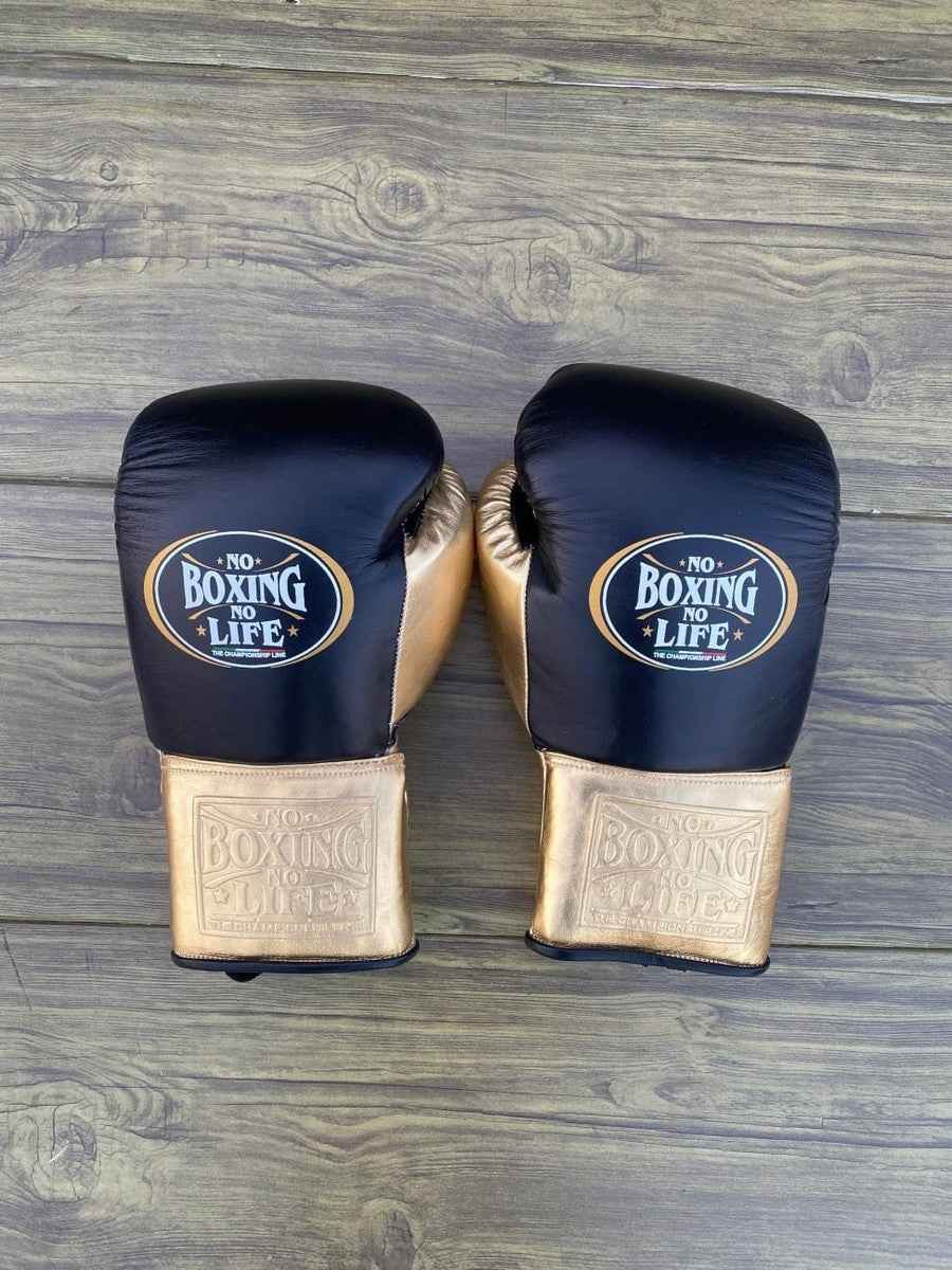 No Boxing No Life custom professional lace-up boxing gloves in black leather with metallic gold cuffs and palms.