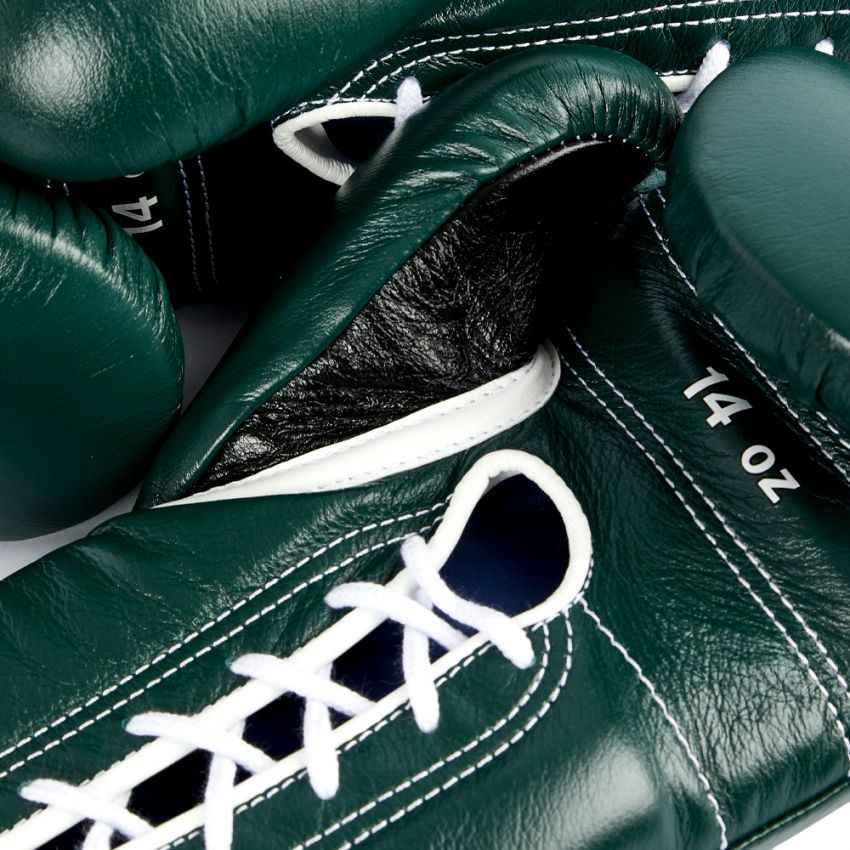 Close-up of green boxing gloves with white laces and '14 oz' label.