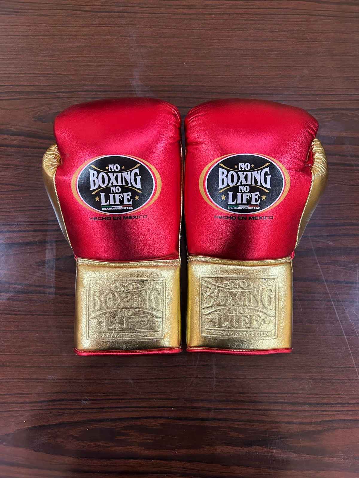 Authentic No Boxing No Life professional boxing gloves in metallic red with metallic gold cuffs and official branding.