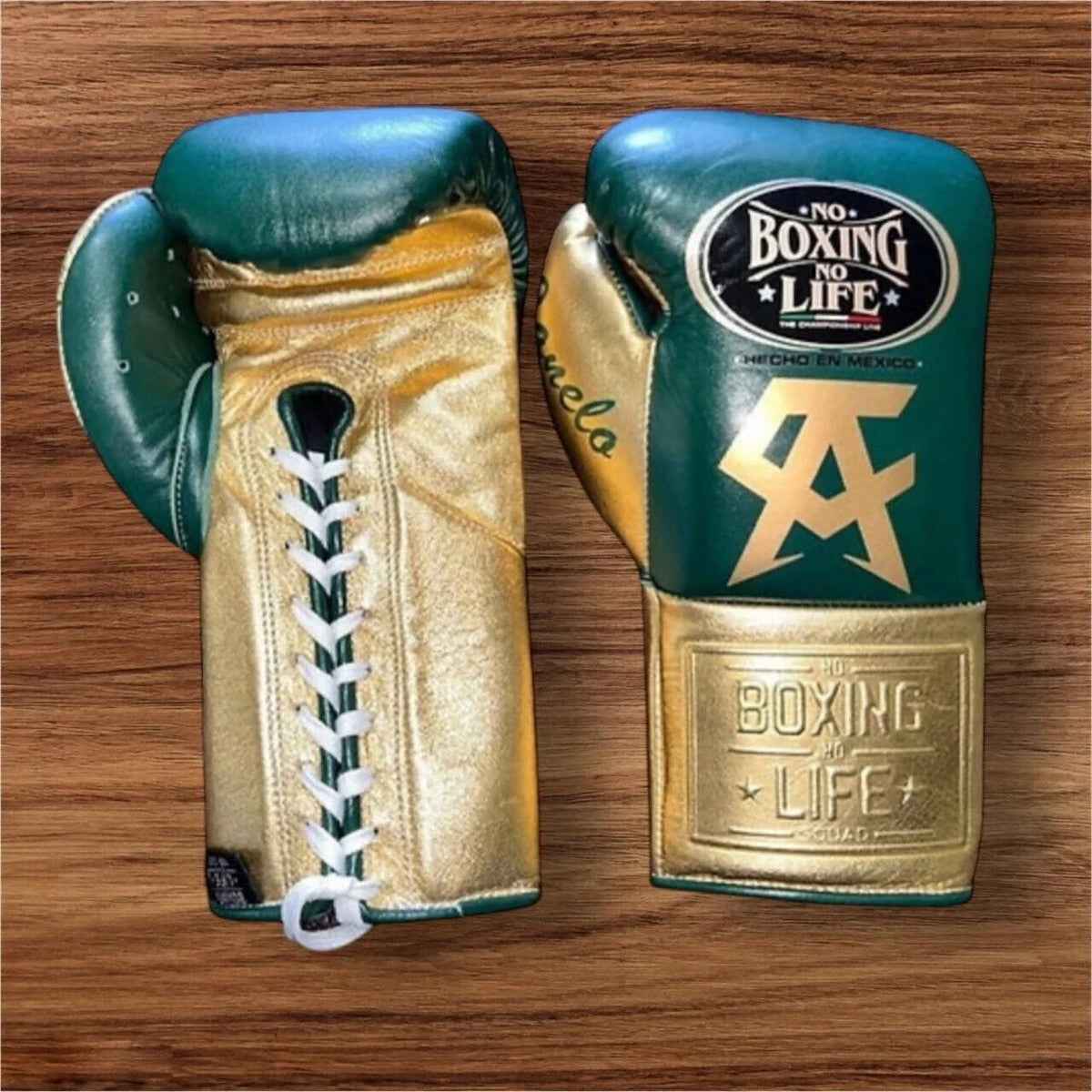 No Boxing No Life professional lace-up boxing gloves in deep green leather with a metallic gold thumb, palm, and cuff area featuring the official brand patches and gold Canelo Alvarez CA logos.