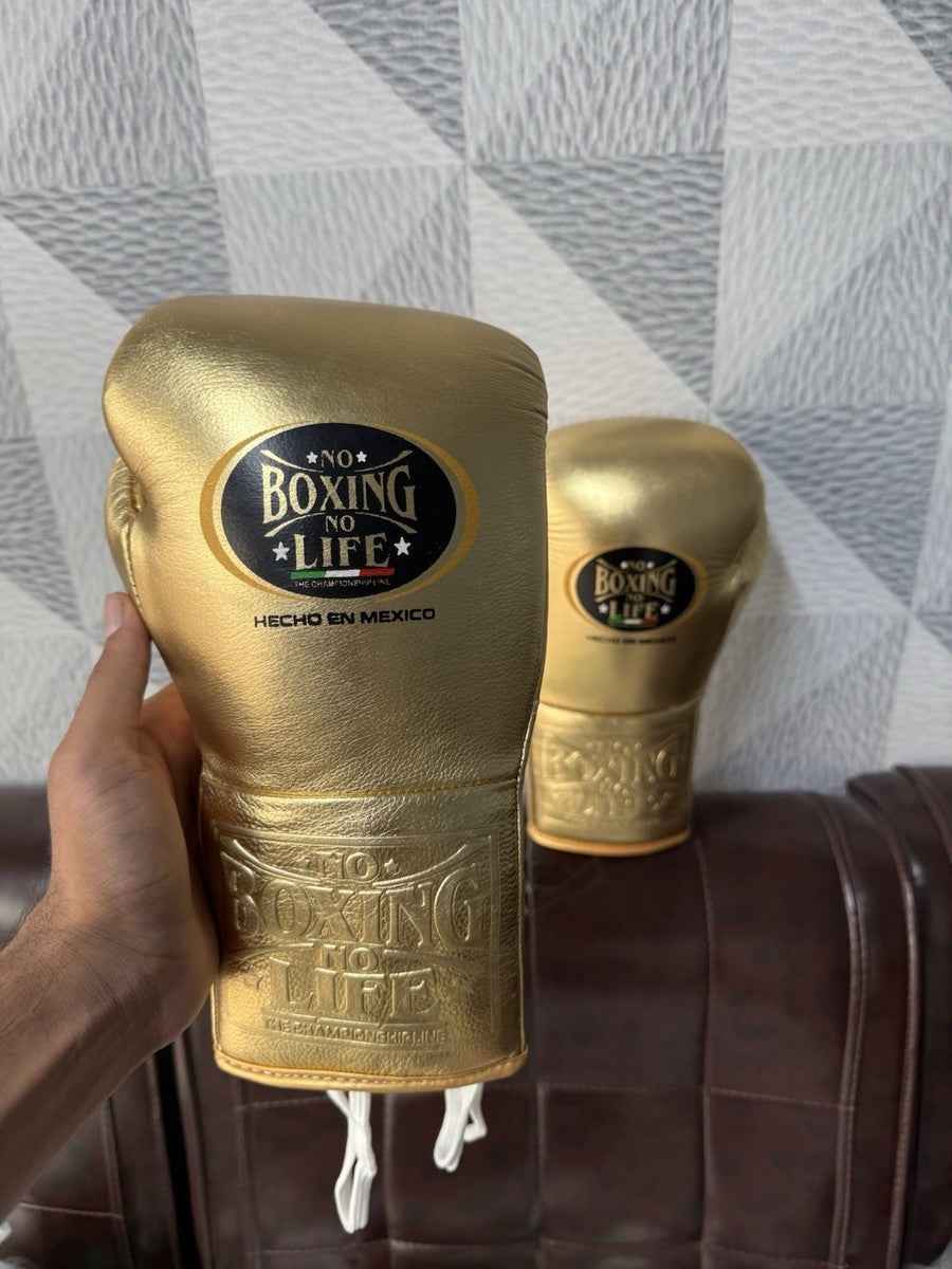 No Boxing No Life professional lace-up boxing gloves in full metallic gold leather featuring the official brand patch and contrasting white laces.