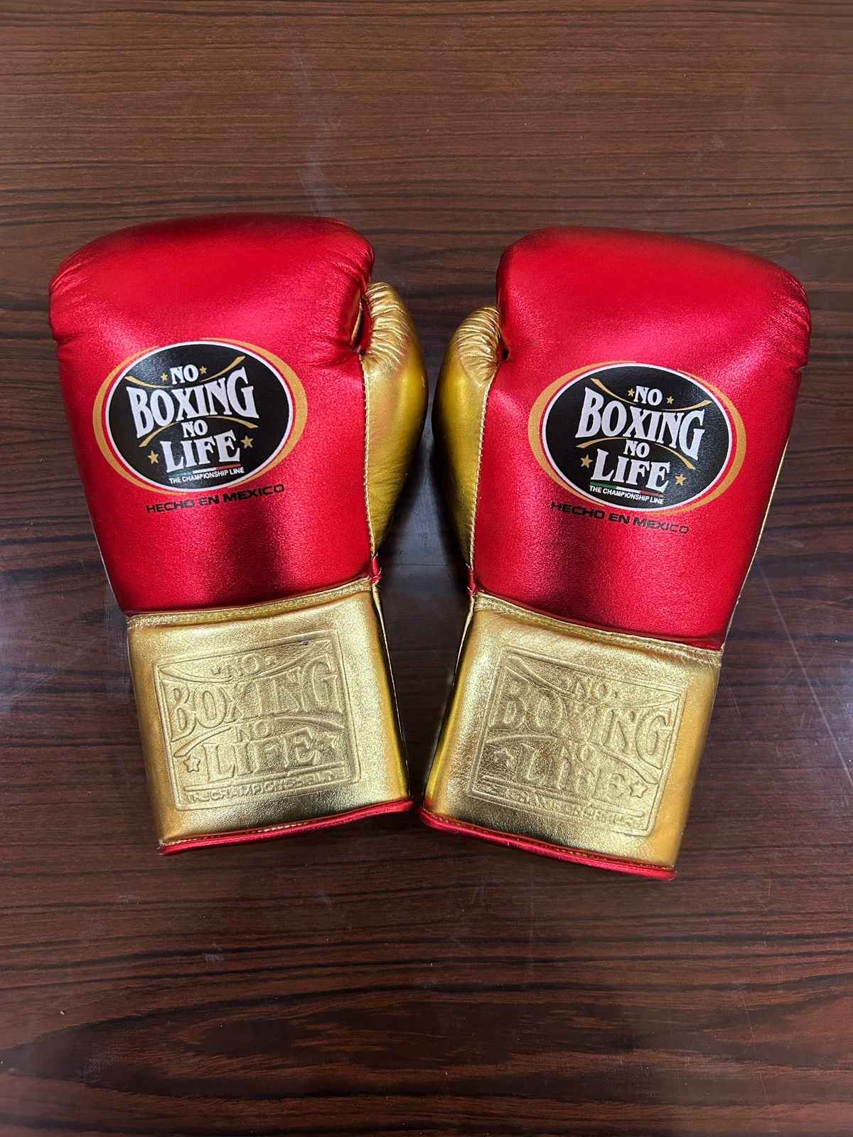 Authentic No Boxing No Life professional boxing gloves in metallic red with metallic gold cuffs and official branding.