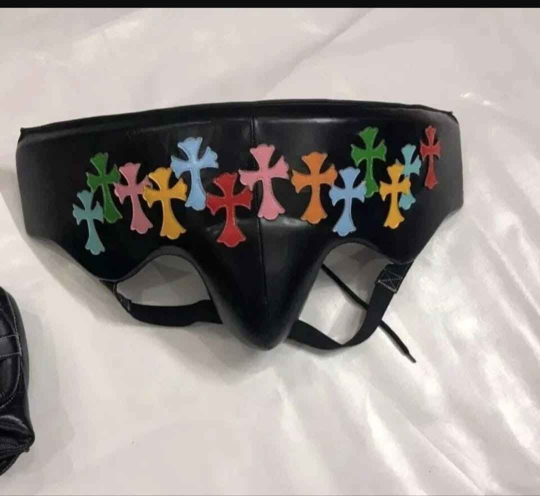 Custom Winning professional 3-piece boxing sparring gear set in black leather featuring multi-colored cemetery cross patches and streetwear graphics across the lace-up gloves, face guard headgear, and groin protector.