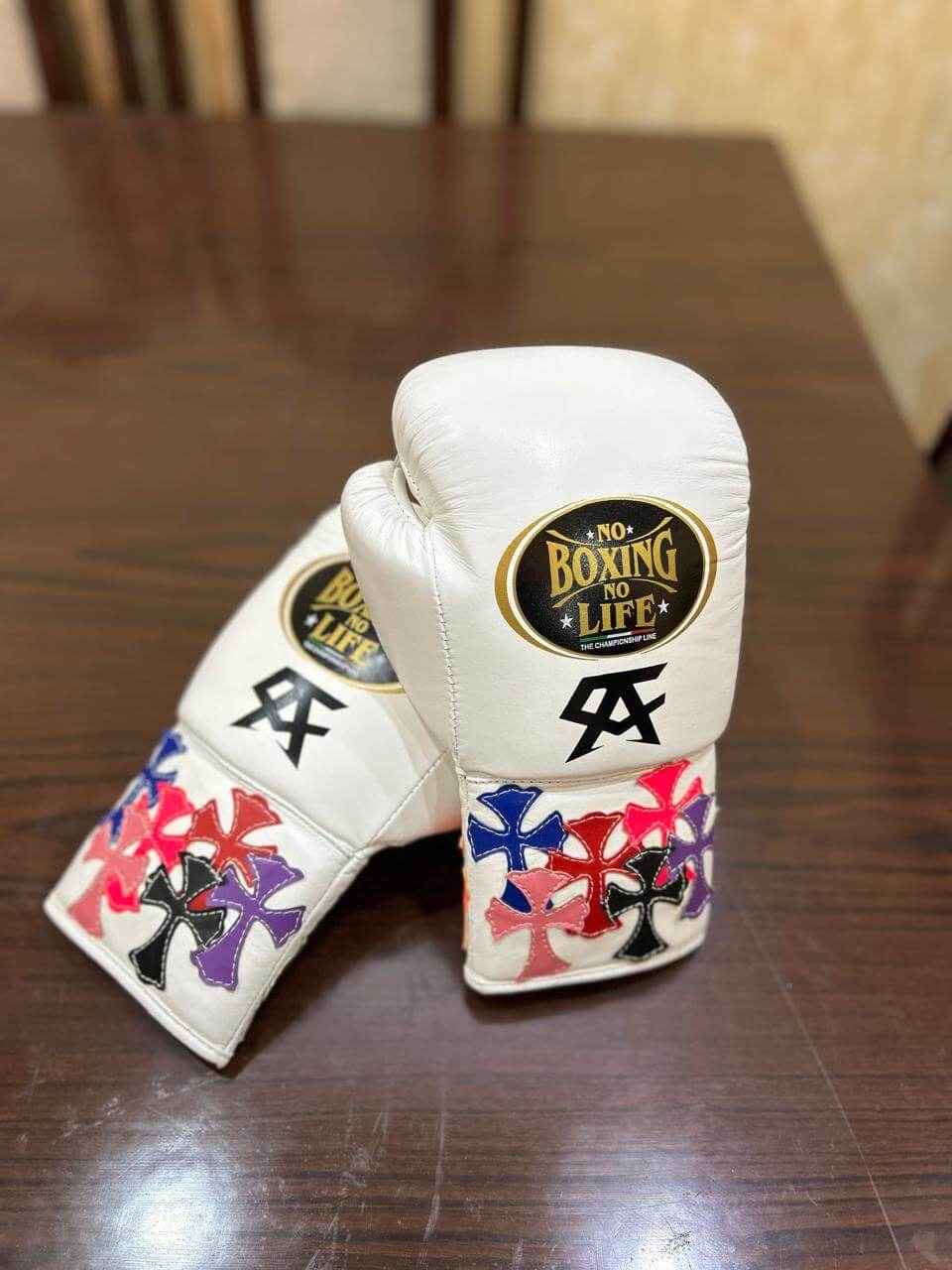 Custom No Boxing No Life professional lace-up boxing gloves in white leather featuring black Canelo Alvarez CA logos and multiple layered multi-color leather cross patches stitched onto the cuffs.