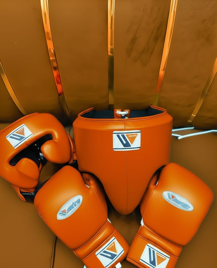 Official Winning professional 3-piece boxing sparring gear set in a matching premium gold tan leather colorway, featuring lace-up training gloves, a face guard headgear, and a groin protector resting together.