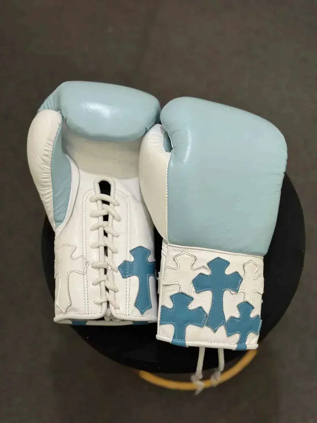Custom Winning professional lace-up boxing gloves in sky blue and white leather featuring multiple layered sky blue leather cross patches stitched onto the white cuffs.