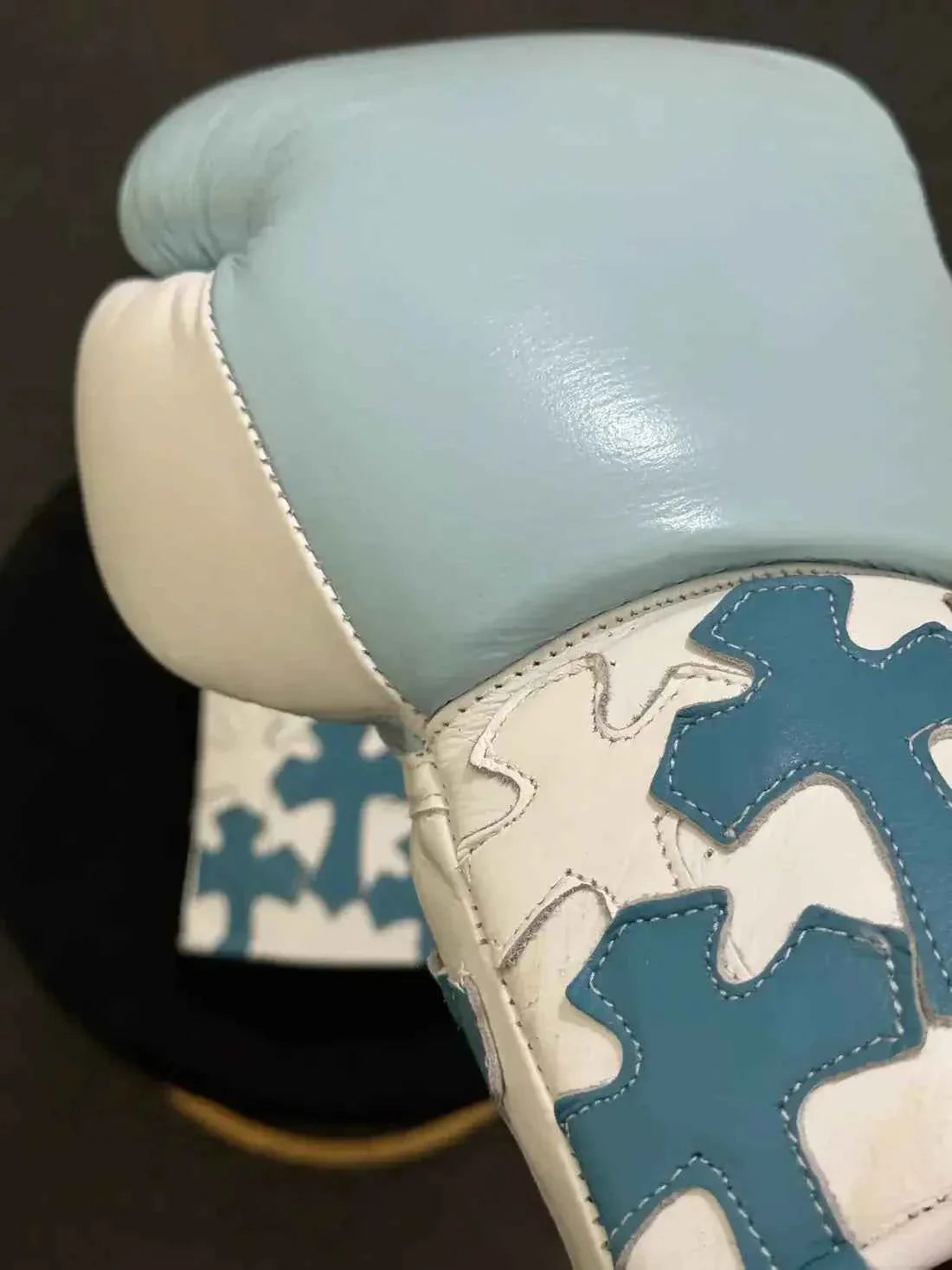 Custom Winning professional lace-up boxing gloves in sky blue and white leather featuring multiple layered sky blue leather cross patches stitched onto the white cuffs.