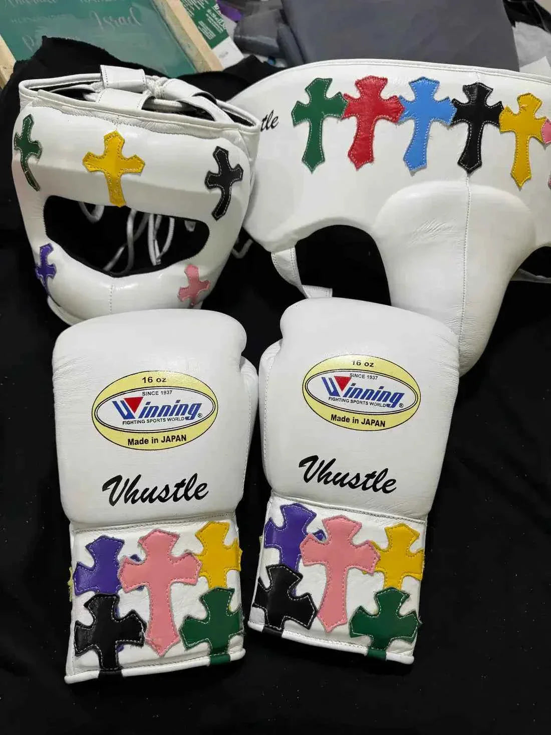 Custom White Winning MS-600 professional lace-up boxing gloves handcrafted in Japan featuring multi-colored cross patches on the cuffs.