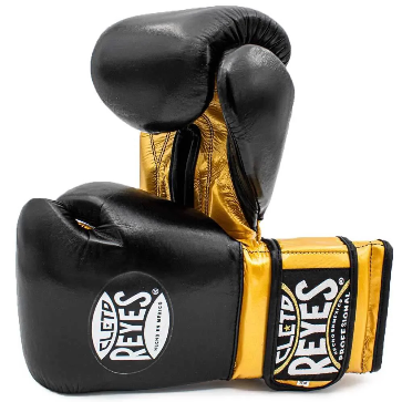 Official Cleto Reyes professional hook-and-loop training boxing gloves featuring a sleek black leather punching face paired with high-sheen gold metallic leather palms, thumbs, and wrist cuffs.