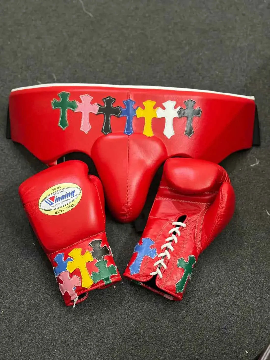 Custom Red Winning MS-300 professional lace-up boxing gloves handcrafted in Japan featuring multi-colored cross patches on the cuffs.