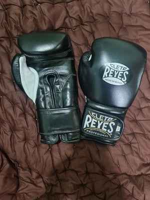 Official Cleto Reyes professional hook-and-loop training boxing gloves in satin black metallic leather featuring a high-sheen dark charcoal finish with white printed brand logos and stitched wrist patches.