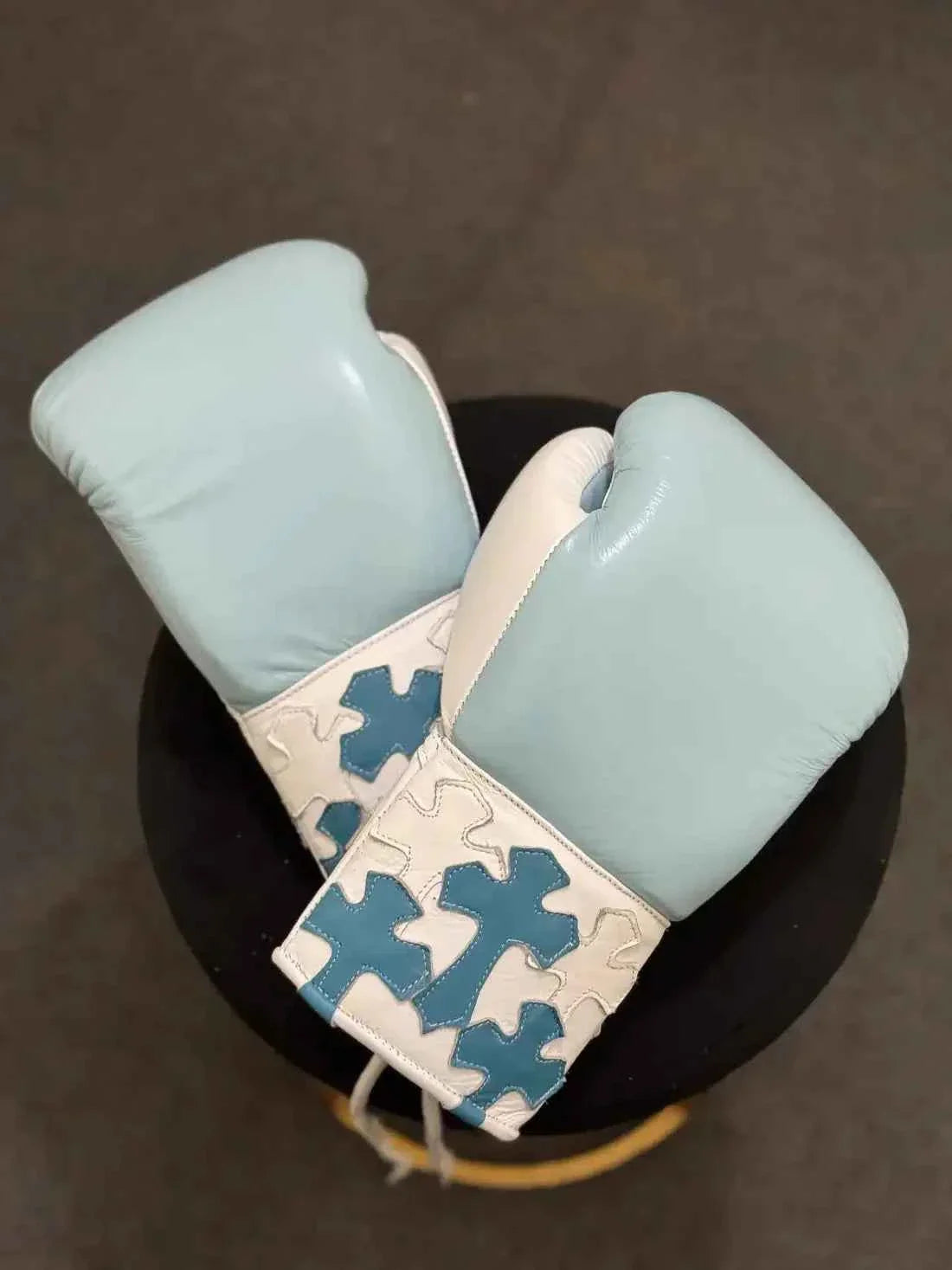 Custom Winning professional lace-up boxing gloves in sky blue and white leather featuring multiple layered sky blue leather cross patches stitched onto the white cuffs.