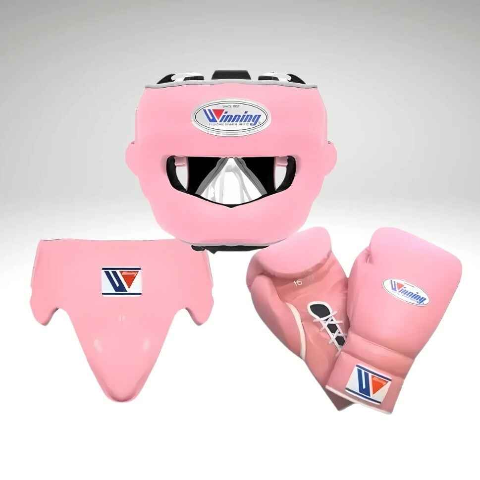 Winning professional custom 3-piece boxing sparring gear set featuring a matching lace-up glove pair, a face-bar headguard, and a groinguard in uniform pastel pink leather with white trim accents.