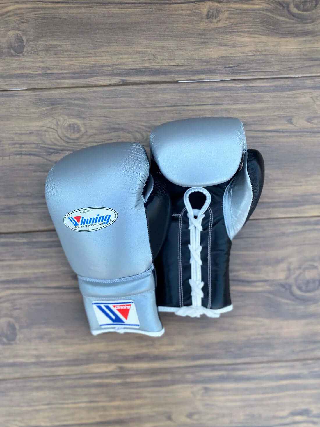 Custom metallic silver and black Winning MS-600 professional lace-up boxing gloves handcrafted in Japan with official branding.