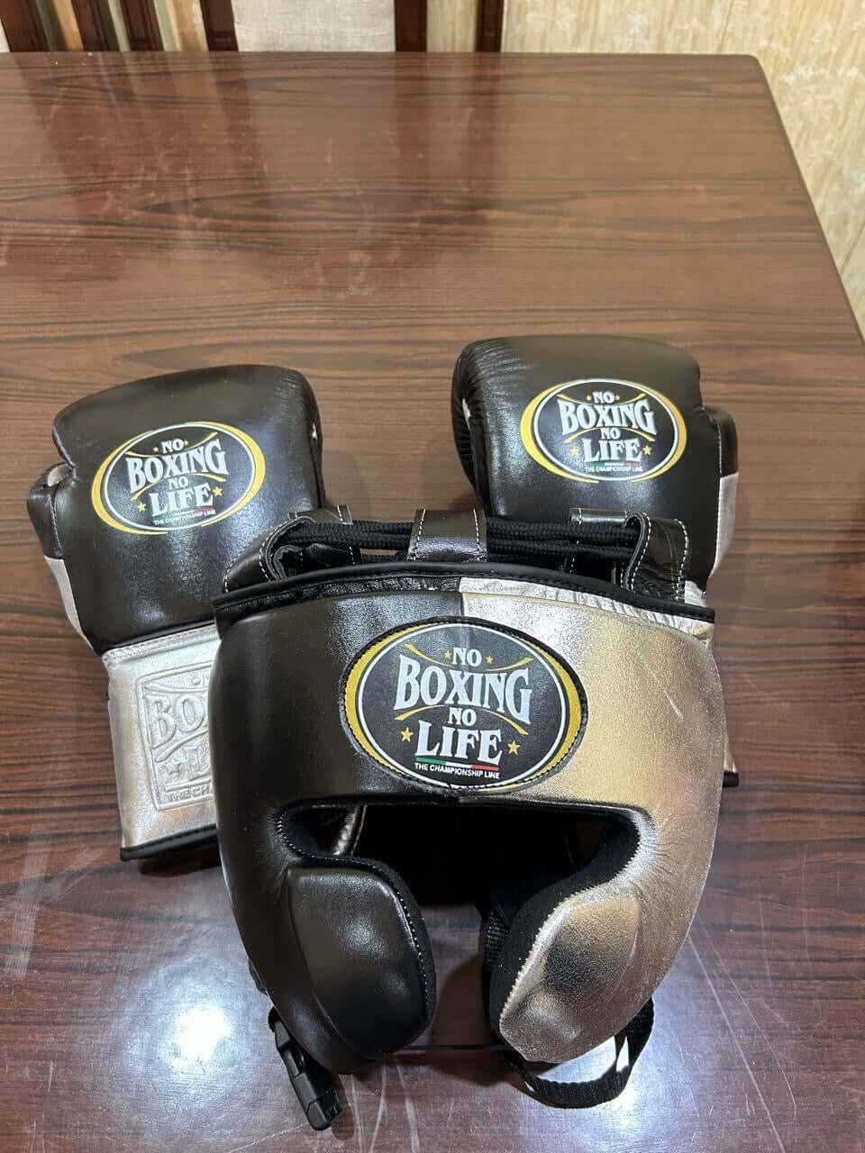 No Boxing No Life professional custom 3-piece boxing sparring gear set featuring matching lace-up gloves, a cheek headguard, and a groinguard in an asymmetrical half black and half metallic silver split leather colorway.