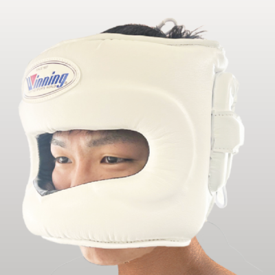 Official Winning FG-5000 professional boxing face bar headgear in classic white premium leather featuring a reinforced front protective bar and the iconic brand logo oval crest on the forehead.