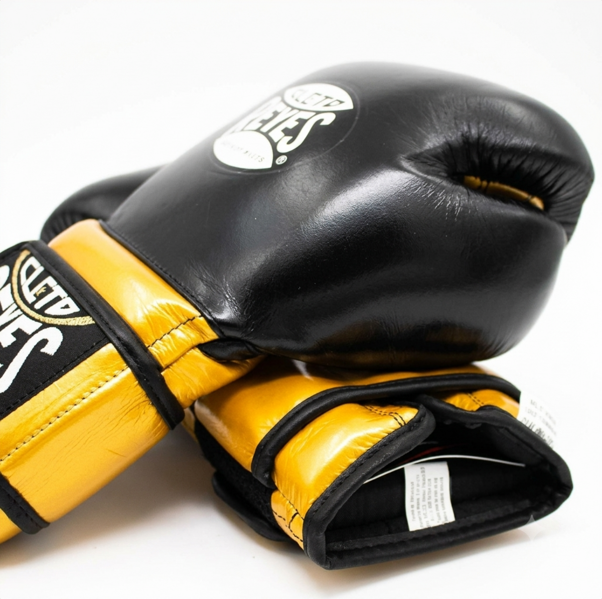 Cleto Reyes black and gold boxing gloves stacked showing wrist strap detail and logo