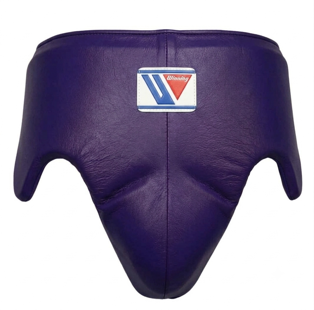 Purple leather boxing headgear with a central logo patch, shown against a plain white background.