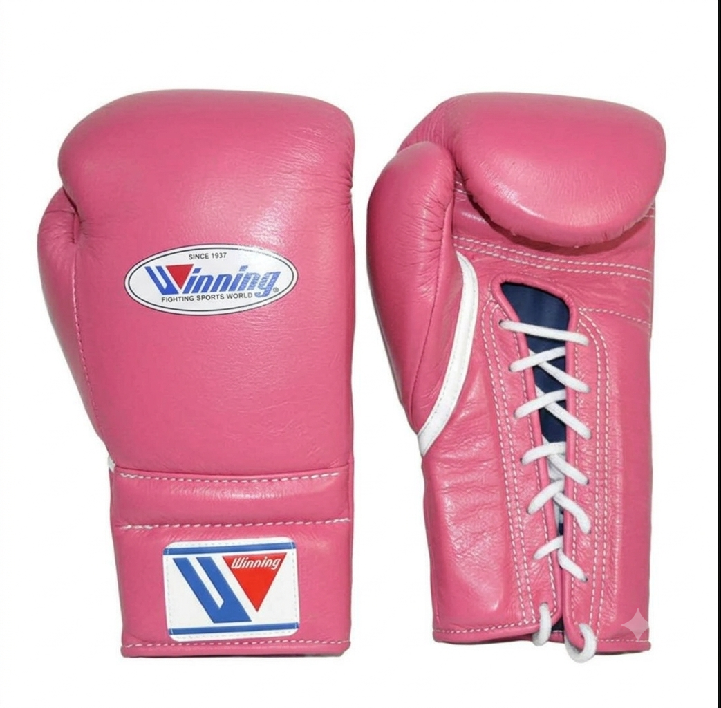 A pair of pink boxing gloves shown against a plain white background, displaying both the front and side views. The gloves feature white laces, a white and blue oval logo on the knuckle, and a matching logo patch on the wrist strap.