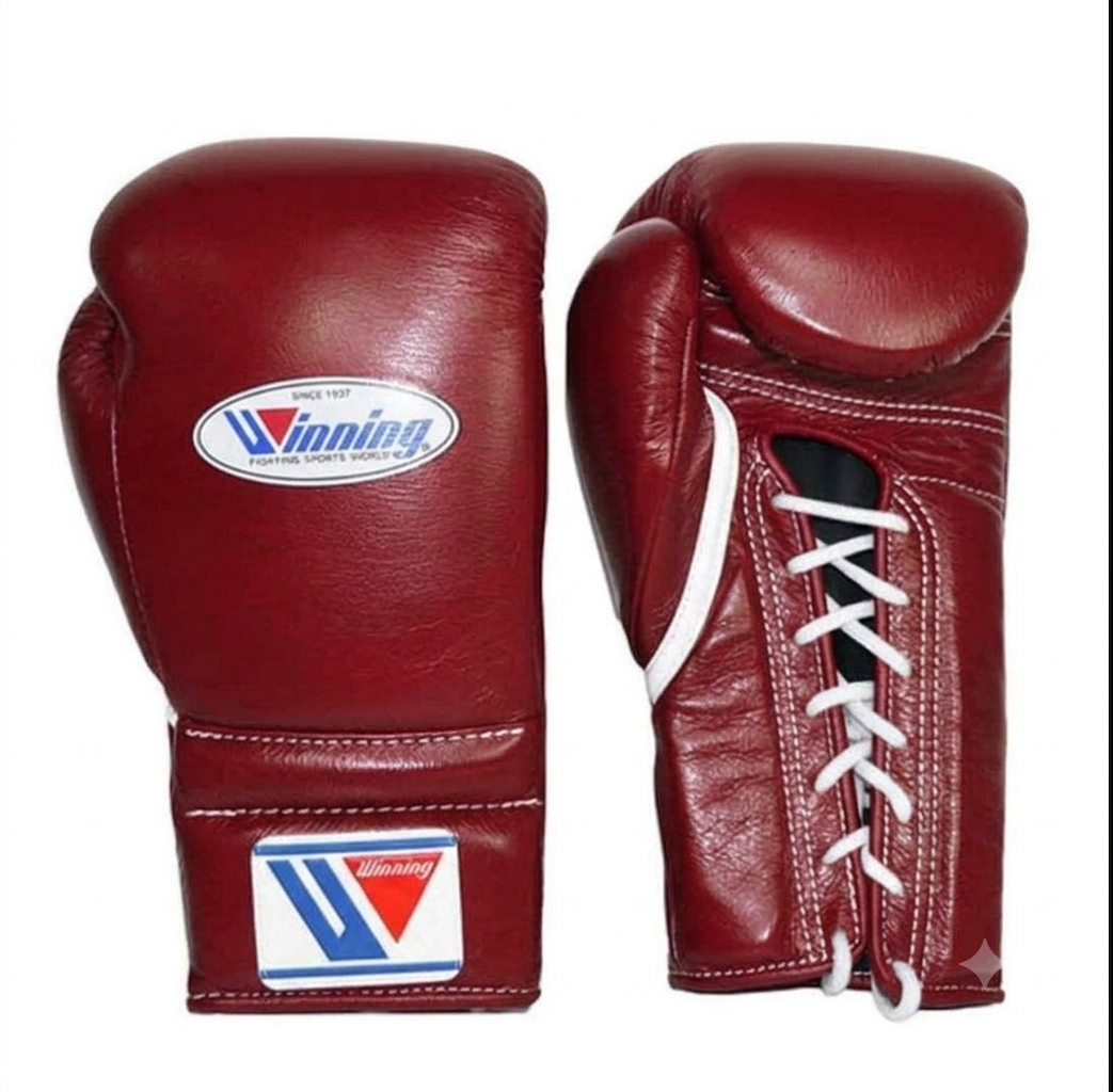A pair of red leather boxing gloves shown from the front and side on a plain white background. The gloves feature white laces, white stitching, and a visible oval and square logo for 'Winning'.