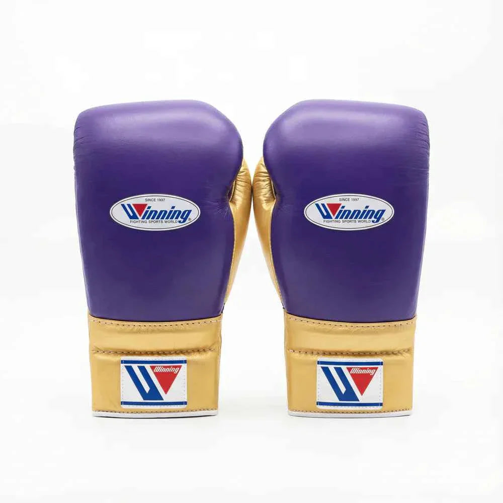 Custom Winning professional lace-up boxing gloves in royal purple leather featuring a metallic gold thumb, metallic gold cuff area, and white official brand patches.