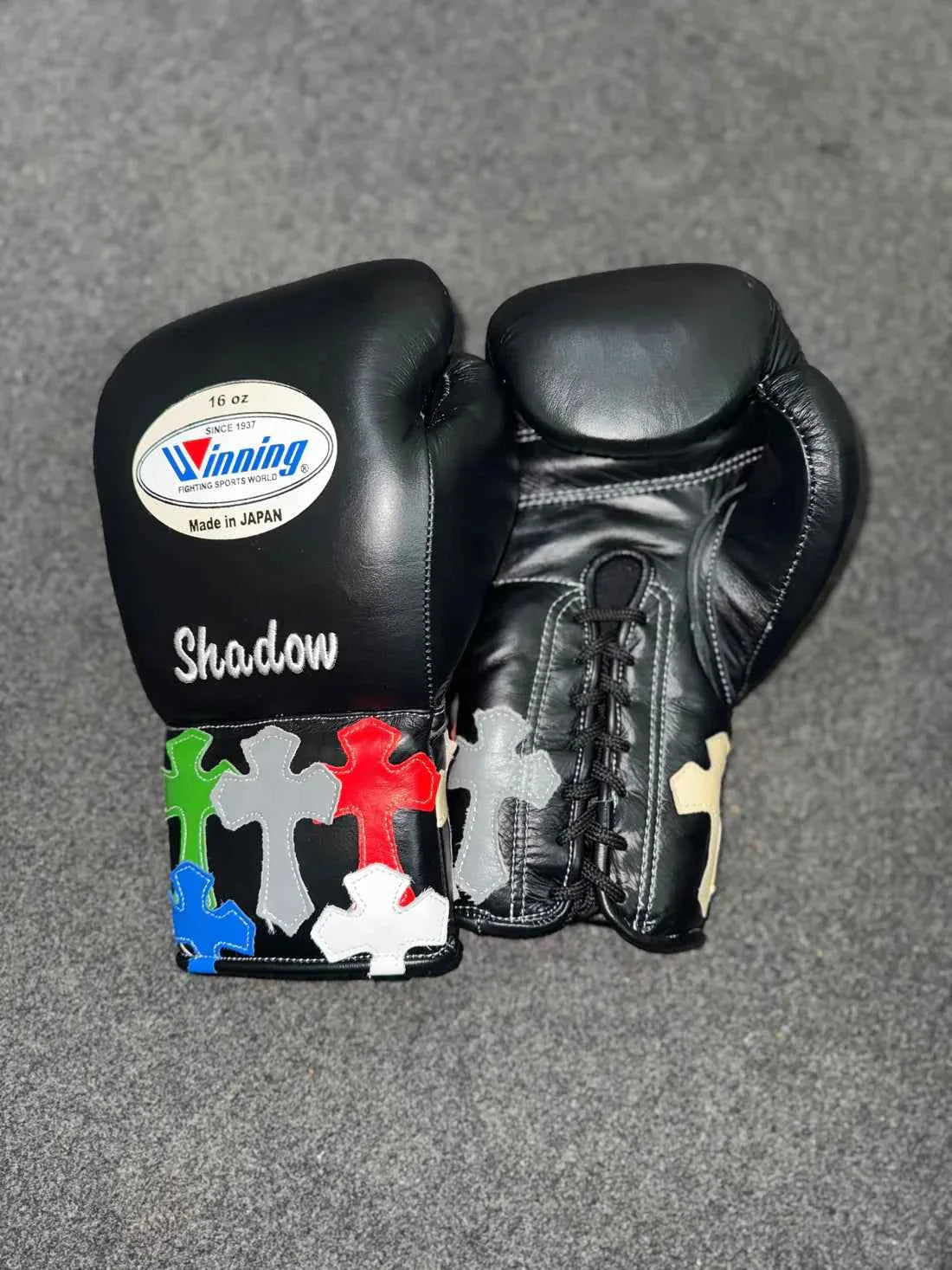Authentic Black Winning MS-300 professional lace-up boxing gloves with custom "Shadow" text and multi-colored cross patches.