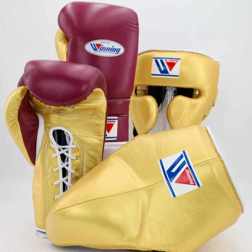Authentic Winning professional boxing set including lace-up gloves, headgear, and groin guard in custom metallic gold and maroon leather.