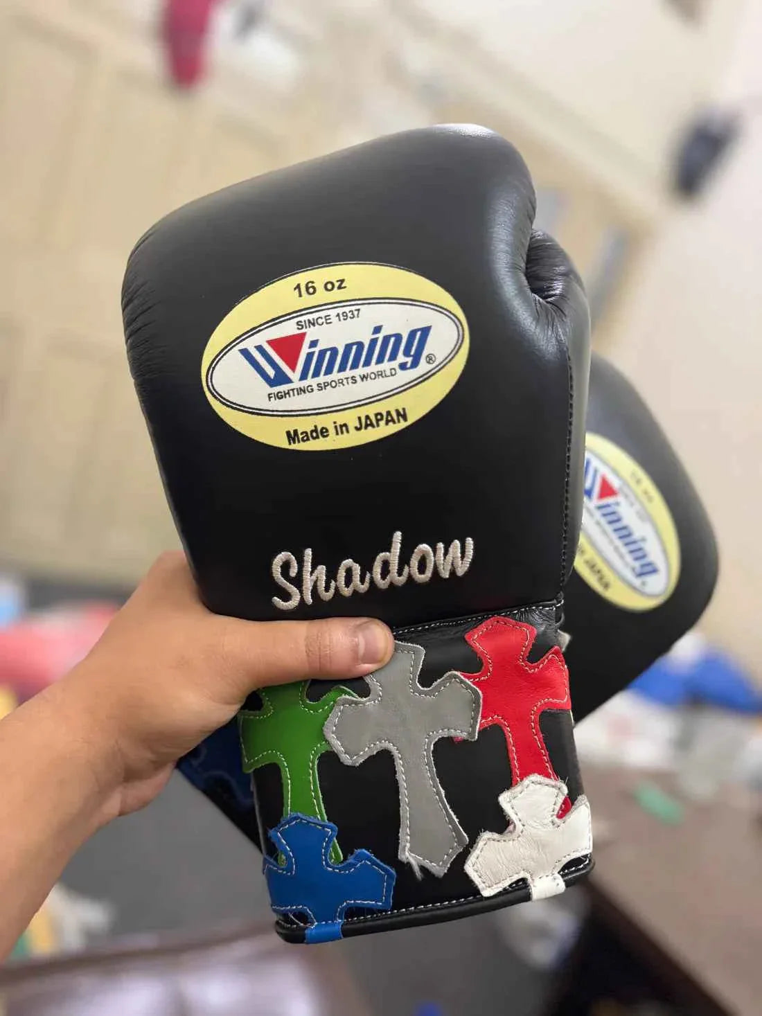Authentic Black Winning MS-300 professional lace-up boxing gloves with custom "Shadow" text and multi-colored cross patches.
