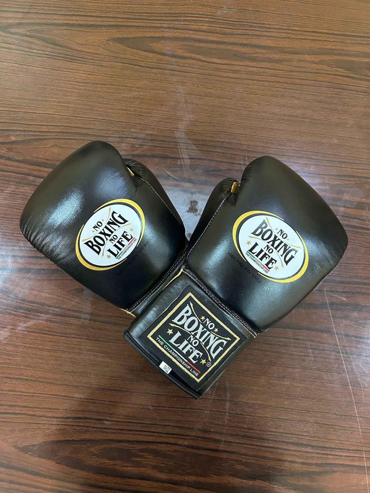 Authentic black and gold No Boxing No Life professional boxing gloves handcrafted in Mexico with official branding.