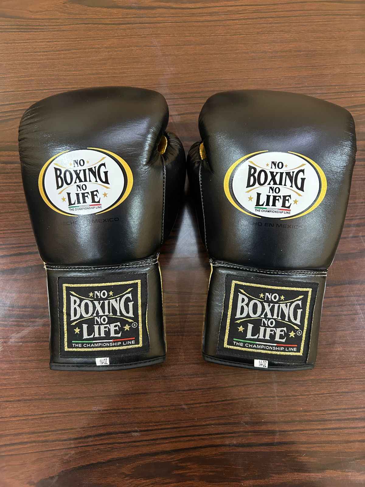 Authentic black and gold No Boxing No Life professional boxing gloves handcrafted in Mexico with official branding.
