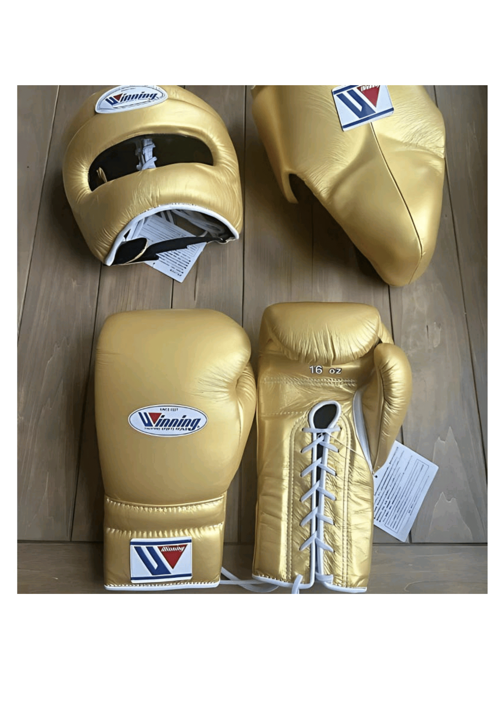 Custom Winning professional 3-piece boxing sparring gear set in a matching shimmering metallic gold premium leather colorway, featuring lace-up training gloves, a face guard headgear, and a groin protector resting on a light wooden surface.