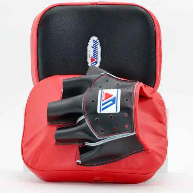 Red boxing mitt with black glove on a white background