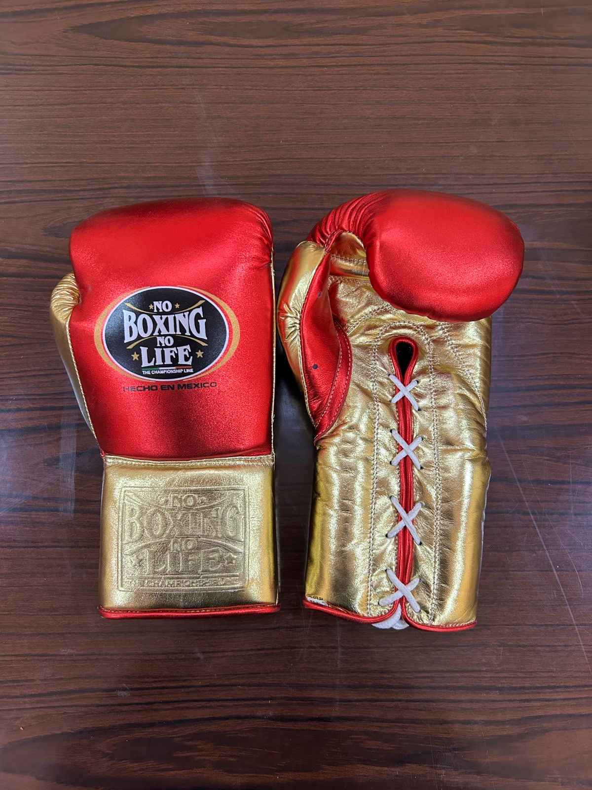 Authentic No Boxing No Life professional boxing gloves in metallic red with metallic gold cuffs and official branding.